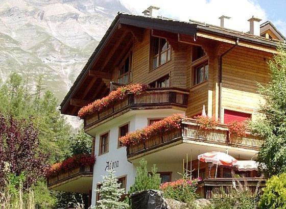 a building with flowers on the balconies of it at Haus Adora in Leukerbad