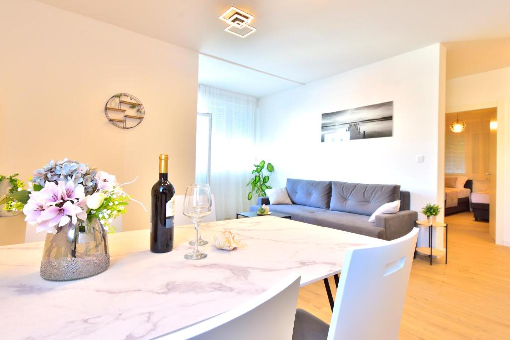 een woonkamer met een tafel met een vaas met bloemen bij Apartman MAIA in Split