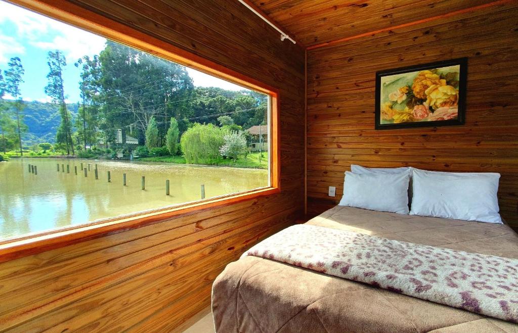 1 dormitorio con ventana grande y cama. en Pousada Mato Verde - Urubici - SC en Urubici