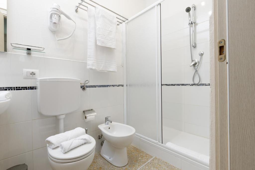a white bathroom with a toilet and a shower at Da Rita Affittacamere in Pisa