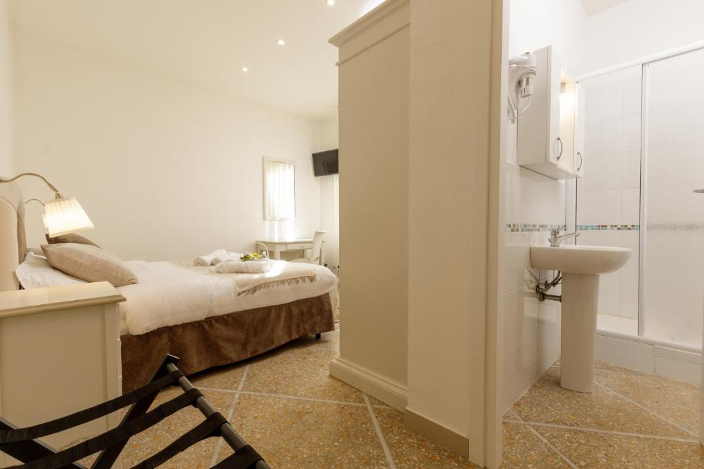 a bedroom with a bed and a sink and a bathroom at Da Rita Affittacamere in Pisa
