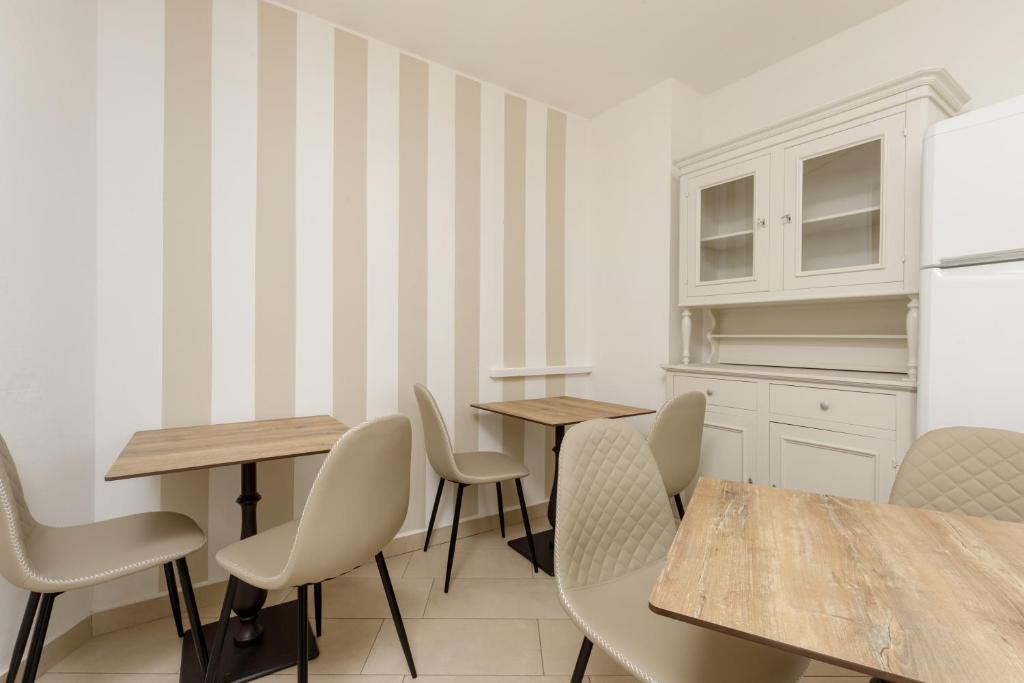 a kitchen with two tables and chairs and a refrigerator at Da Rita Affittacamere in Pisa