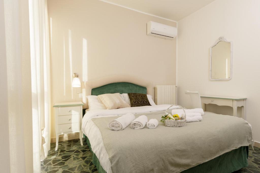 a bedroom with a large bed with towels on it at Da Rita Affittacamere in Pisa