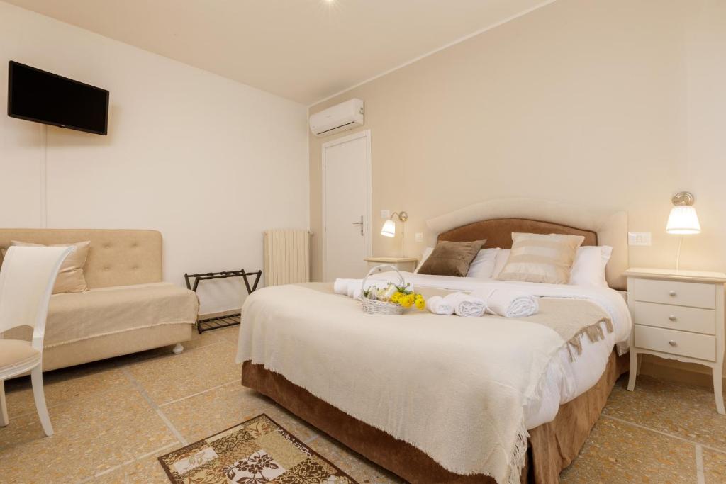 a bedroom with a large bed and a couch at Da Rita Affittacamere in Pisa