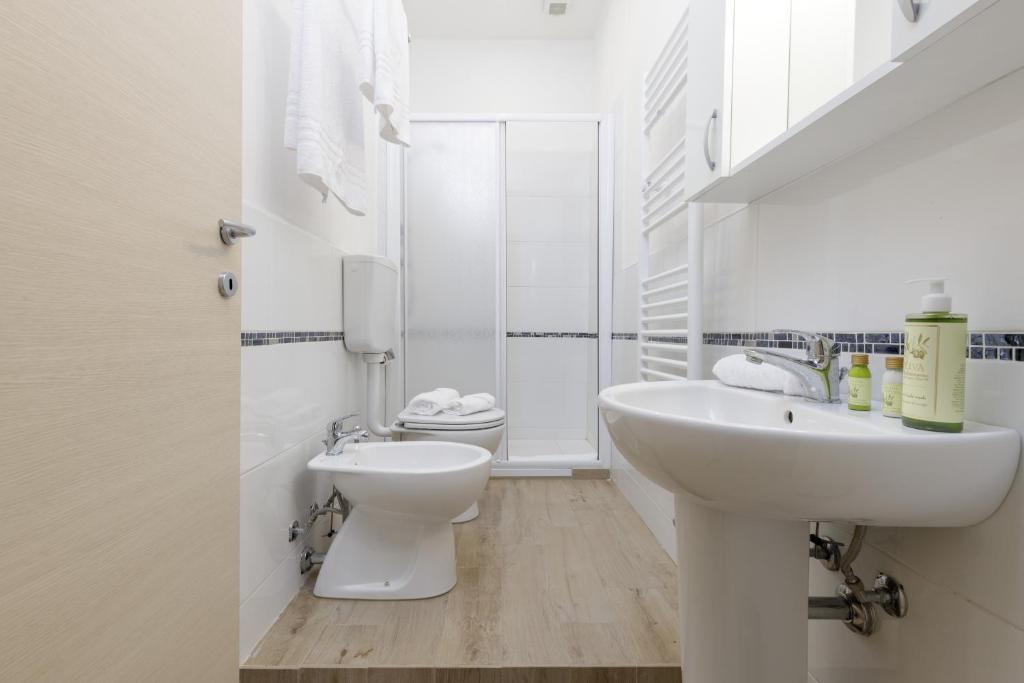 a white bathroom with a sink and a toilet at Da Rita Affittacamere in Pisa
