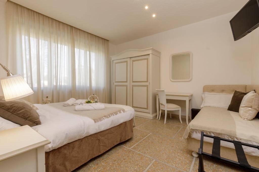 a bedroom with two beds and a table and a desk at Da Rita Affittacamere in Pisa