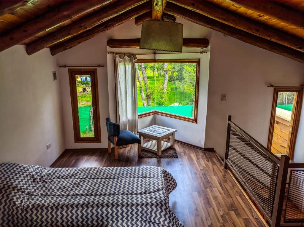 a living room with a couch and two windows at Cabañas Shalom in Lago Puelo