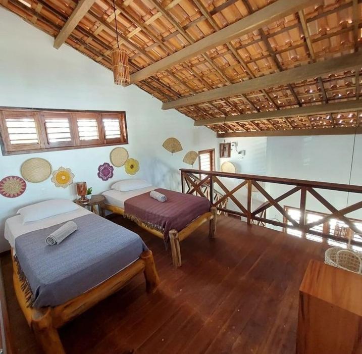una camera da letto con due letti e pavimento in legno di CASA SOLEIL icaraizinho a Icaraí