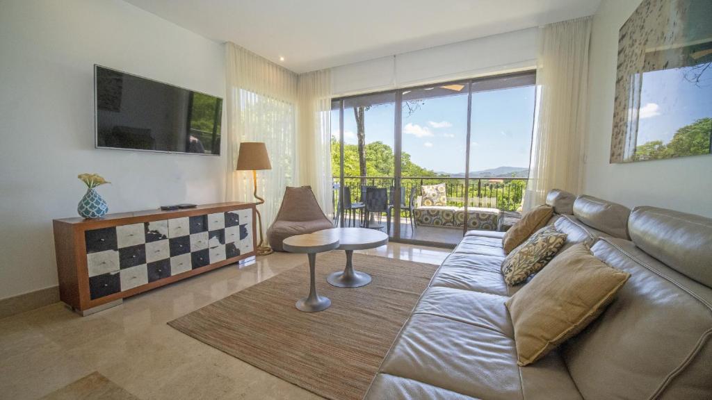 a living room with a couch and a table at Roble Sabana 105 Luxury Apartment - Reserva Conchal in Playa Conchal