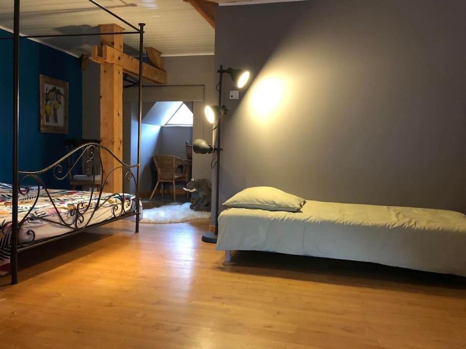 sypialnia z dwoma łóżkami piętrowymi i drewnianą podłogą w obiekcie La Maison de Suzanne w mieście Murol