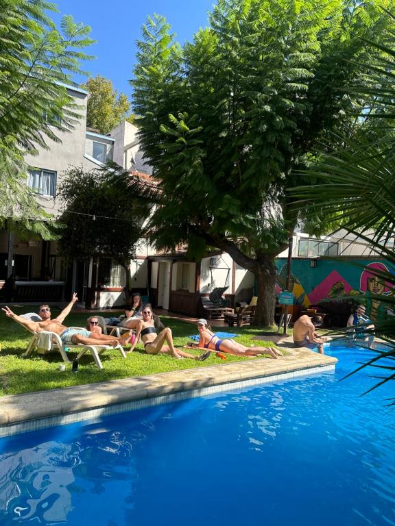 a group of people laying around a swimming pool at Gorilla Hostel in Mendoza