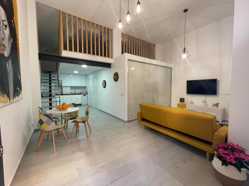ein Wohnzimmer mit einem gelben Sofa und einem Tisch in der Unterkunft Nuevo apartamento Folin in Don Benito