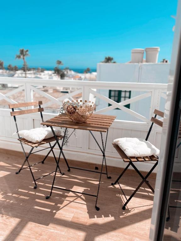 a wooden table and two chairs on a balcony at Casa Rosalia Puerto del Carmen in Puerto del Carmen