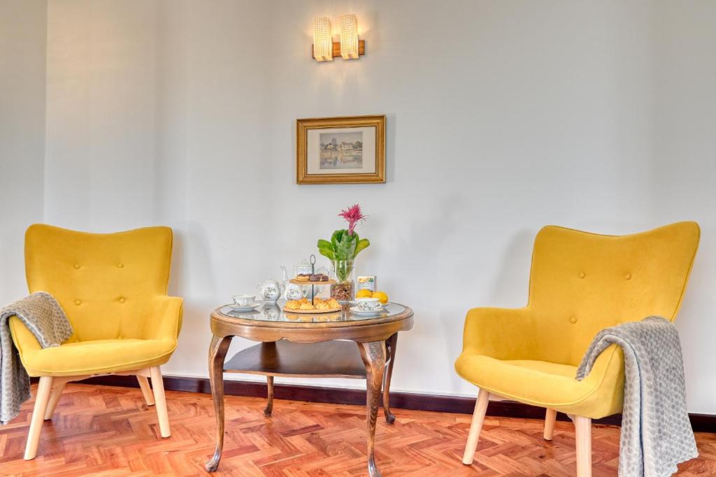 duas cadeiras e uma mesa com uma bandeja de comida em Casa do Valentim, a Home in Madeira em Ponta do Sol