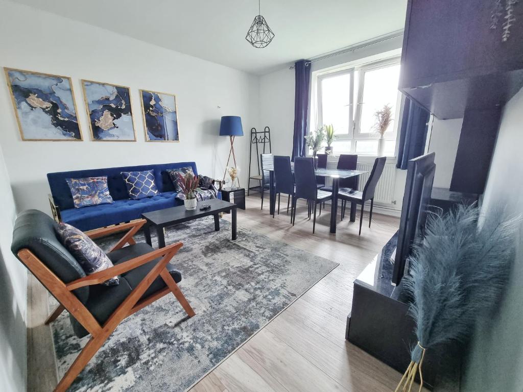 sala de estar con sofá azul y mesa en The Headlam Apartment, en Londres