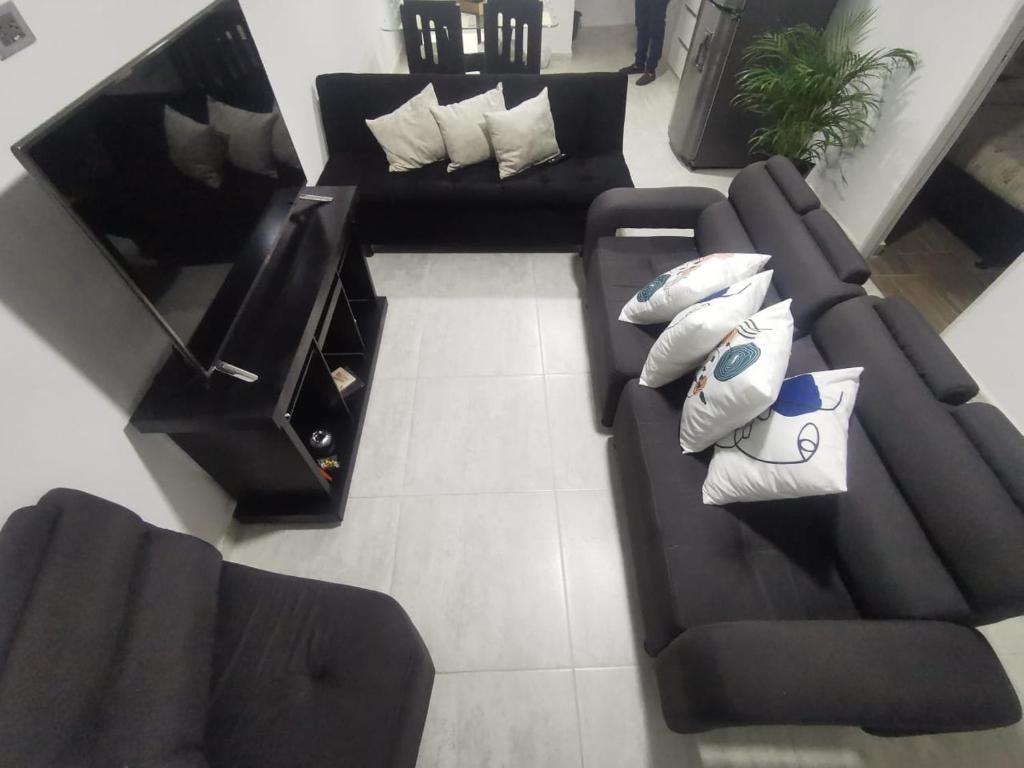 een woonkamer met zwart meubilair bij Hermoso Apartamento en Circasia, Quindío. in Circasia