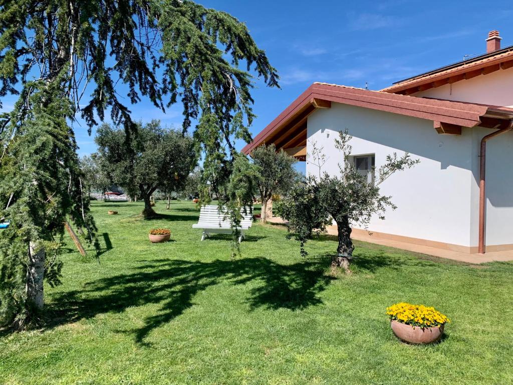 a house with a yard with trees and a bench at B&B La Casa Del Sole in Sala Baganza