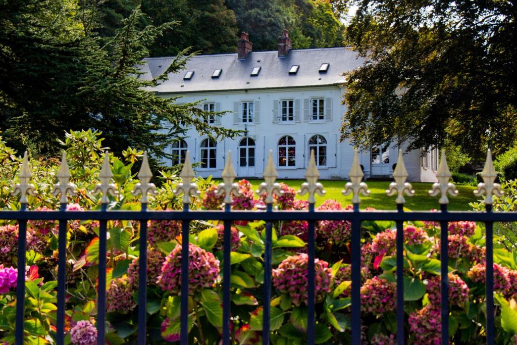 une clôture devant une maison blanche ornée de fleurs dans l'établissement Château du Romerel - Baie de Somme, à Saint-Valery-sur-Somme