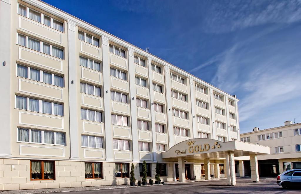 a large white building with a sign in front of it at Hotel Gold in Dębica