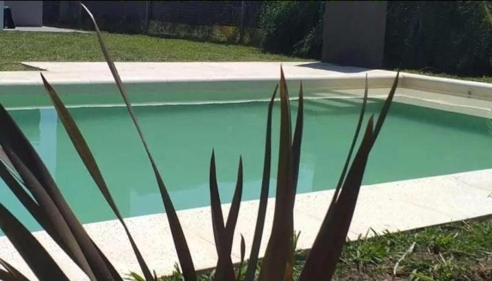 una piscina azul junto a una casa en Descanso en Las Acequias en Roldán