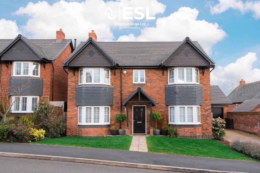 a red brick house with a black roof at Large Modern 3 Bedroom House in Uttoxeter, Near Alton Towers, Great for Families in Uttoxeter
