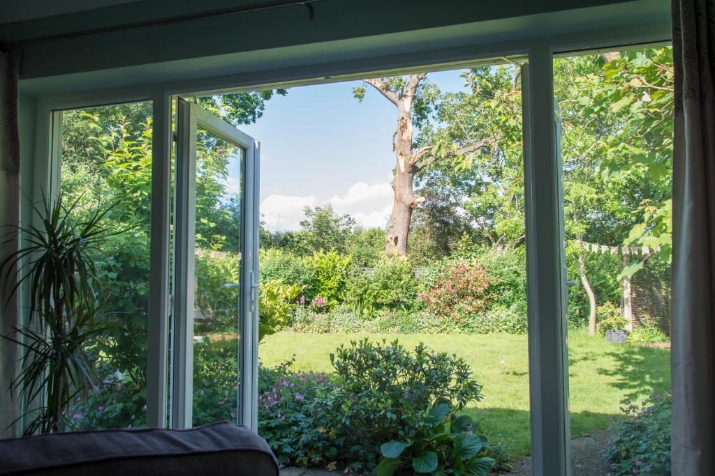 a sliding glass door looking out at a garden at Luxury Self Catering in Colchester in Colchester