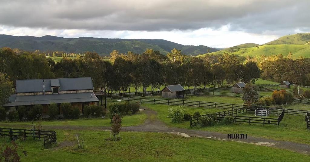 a view of a farm with mountains in the background at The Stables - Farm Stay in Strath Creek