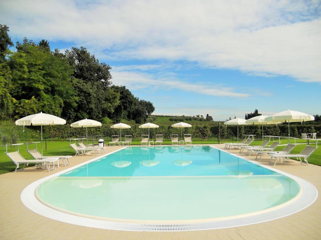 a large swimming pool with chairs and umbrellas at Appartamento Ai Prati in Lazise