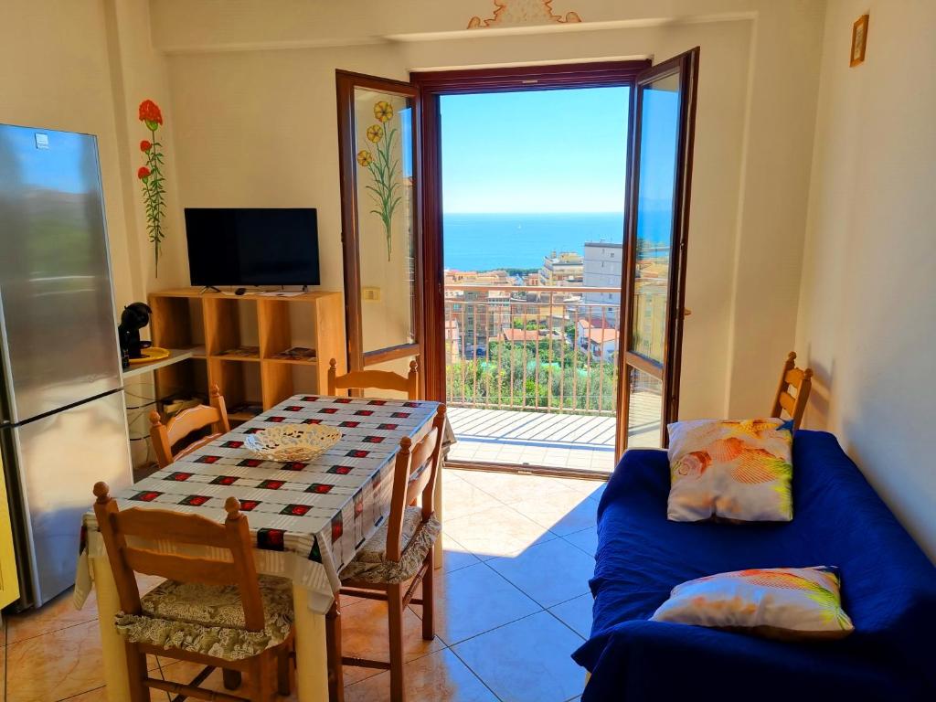 een woonkamer met een tafel en uitzicht op de oceaan bij Via Pasquale Testa in Formia