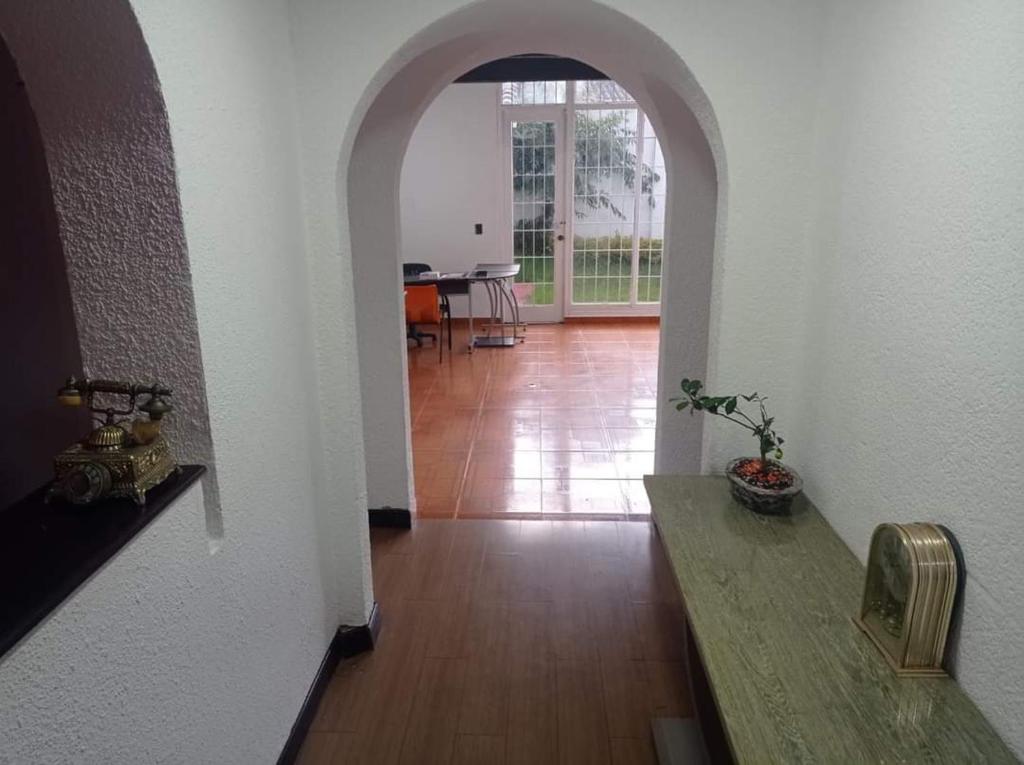 a hallway with an archway and a table in a room at Hotel Bogotá Calle 100 in Bogotá