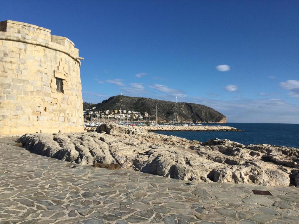 a stone building on the shore of a beach at Appartment Kristal Mar II in Moraira