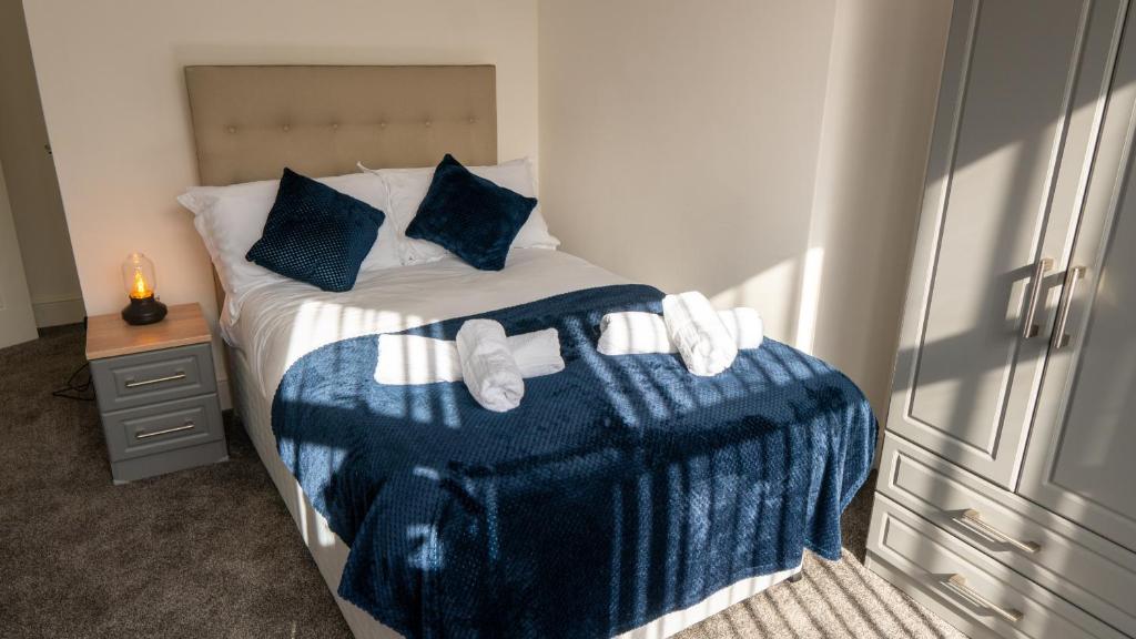 um quarto com uma cama com um cobertor azul e branco em Reedley House em Nelson