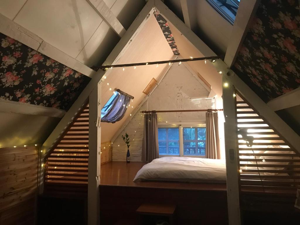 a bedroom with a bed in a attic with lights at Bridge12th B&amp;B in Yanliau