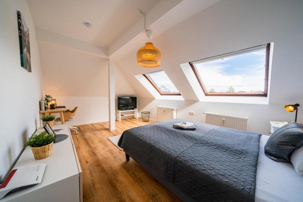Schlafzimmer mit einem Bett, einem Schreibtisch und einem TV in der Unterkunft STYLE-Apartment I Klimaanlage I WLAN I Küche I Smart-TV in Magdeburg