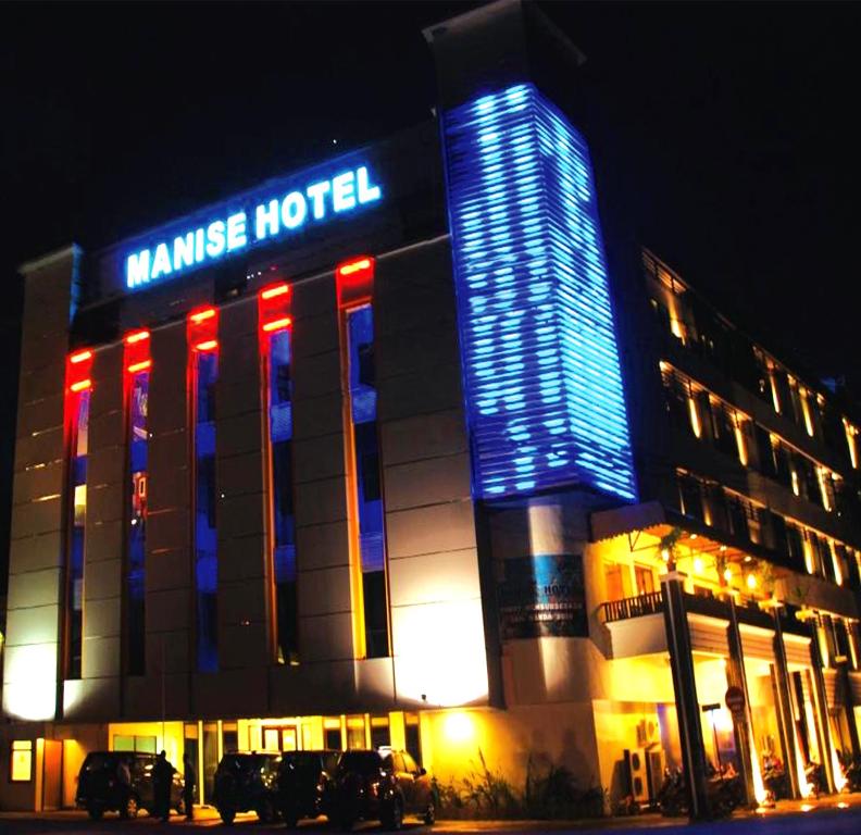 un hôtel avec des lumières bleues et rouges devant lui dans l'établissement Manise Hotel, à Ambon