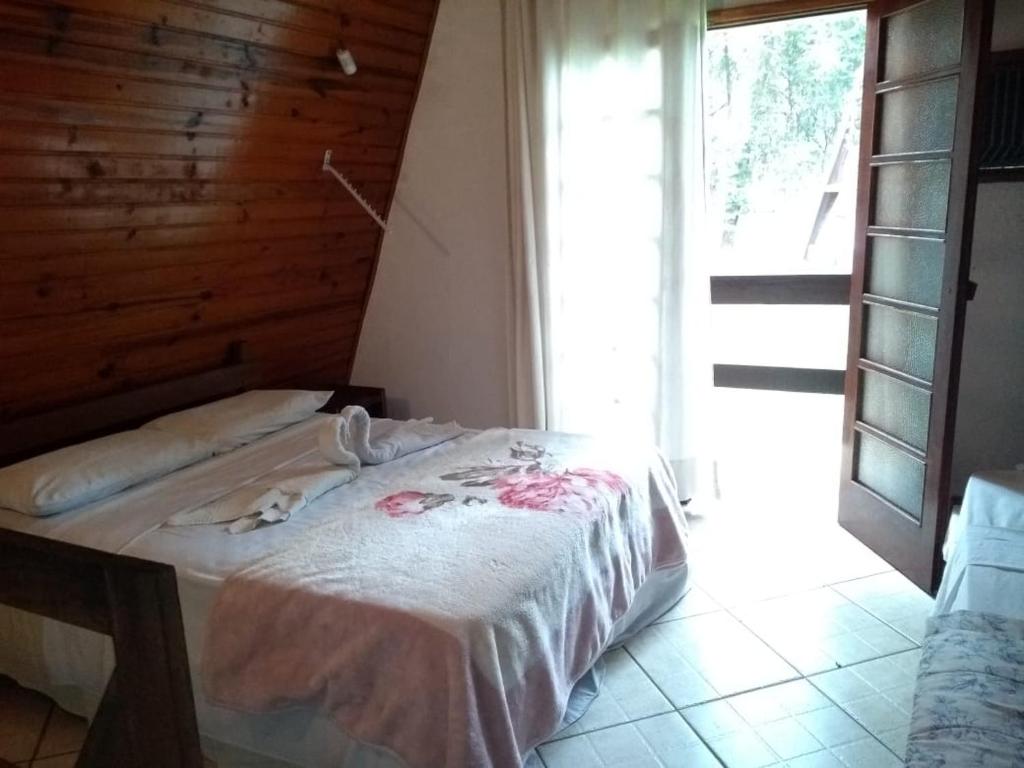 Vila Chale في باورو: غرفة نوم مع سرير في غرفة مع نافذة