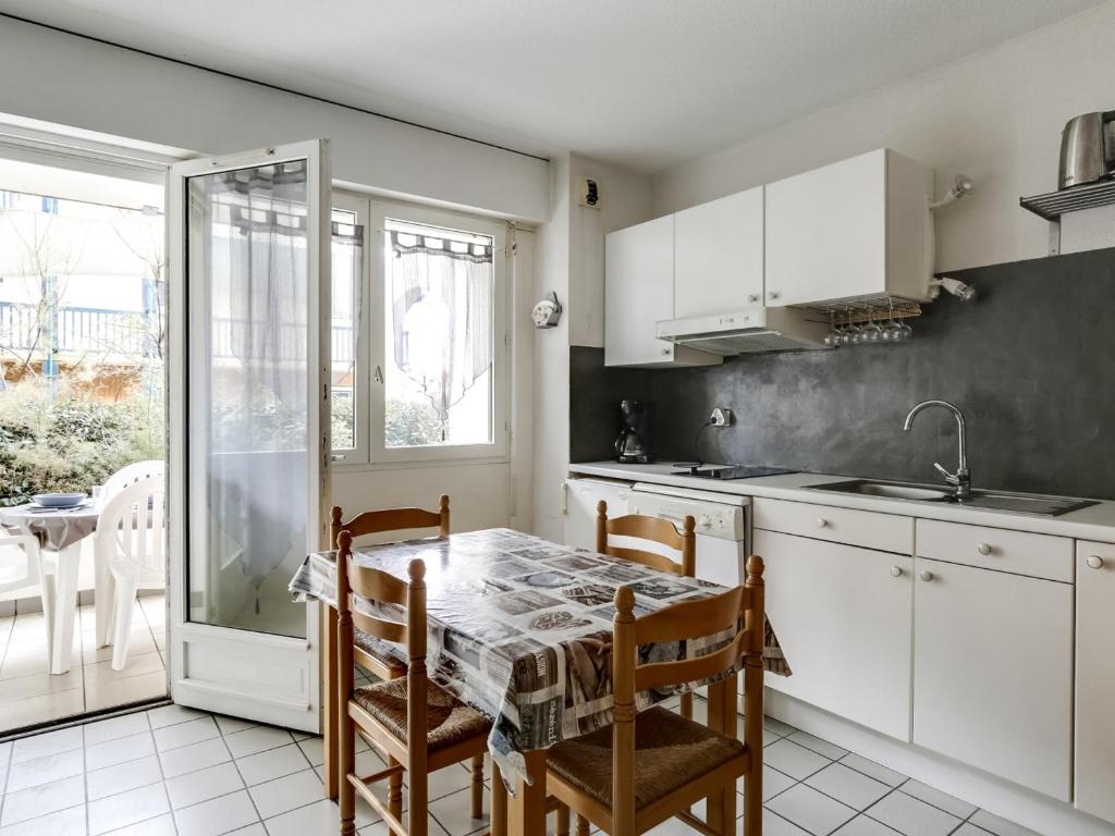 une cuisine avec des armoires blanches et une table avec des chaises dans l'établissement Appartement T2 cabine à Biscarrosse-Plage, proche océan, 4 pers. - FR-1-521-84, à Biscarrosse-Plage