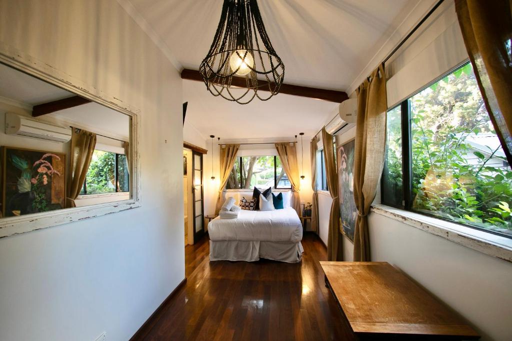 a bedroom with a bed and a chandelier at Rústicoq B+B in Cowaramup