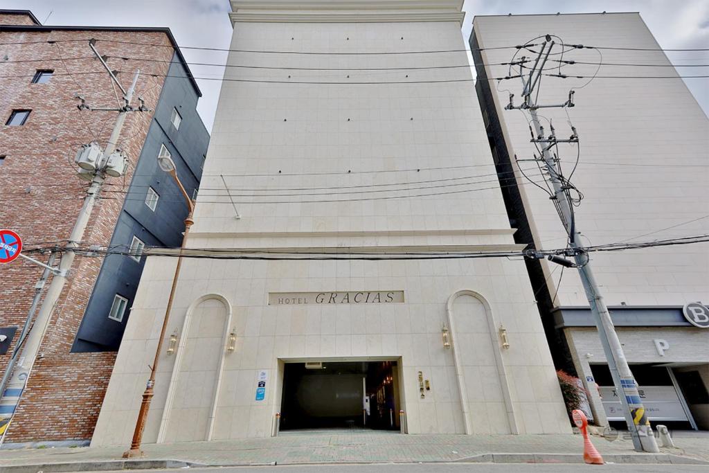金海市Gracias Hotel Gimhae的大型白色建筑,设有大门廊