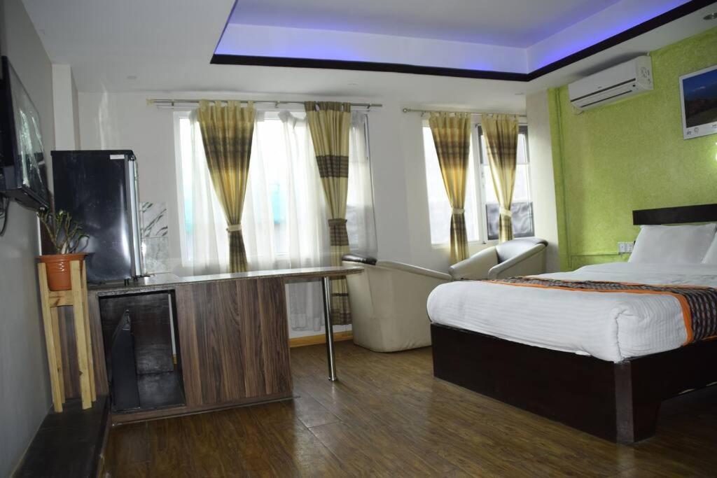 1 dormitorio con 1 cama y TV en una habitación en Panoramic apartment in peaceful location of Thamel, en Katmandú