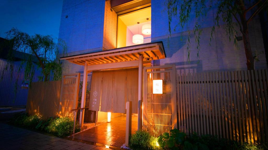 una casa con una puerta y una valla en Waqoo Shitaderamachi en Osaka