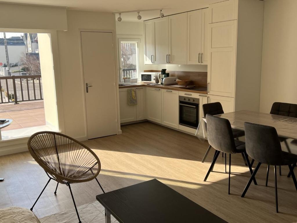 kuchnia i salon ze stołem i krzesłami w obiekcie Appartement 3 pièces avec terrasses et vue mer - Parking inclus - FR-1-487-349 w mieście Cabourg