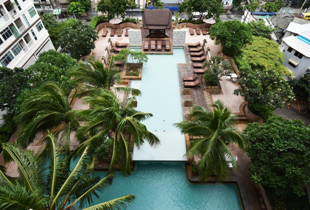 an overhead view of a swimming pool with palm trees at Century Park Hotel - SHA Extra Plus in Bangkok