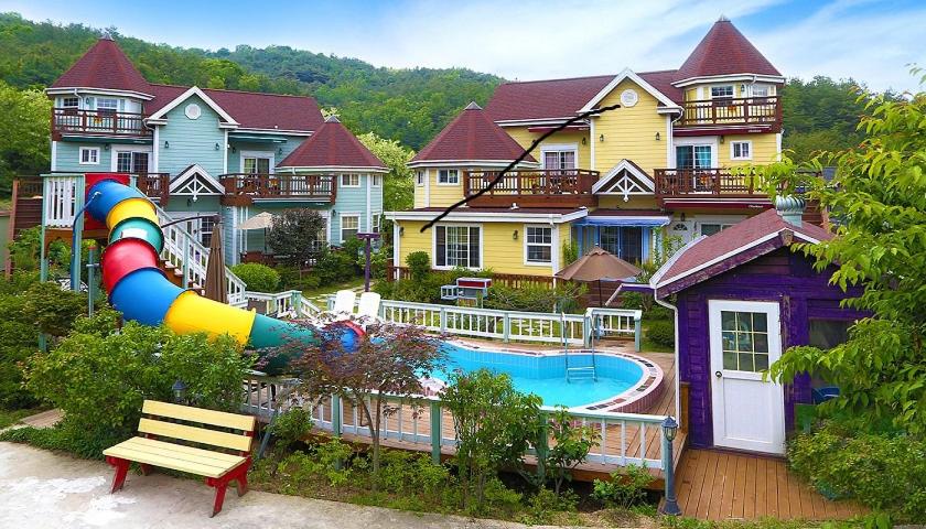 a group of houses with a pool and a slide at Olive Vanilla Pension in Gyeongju