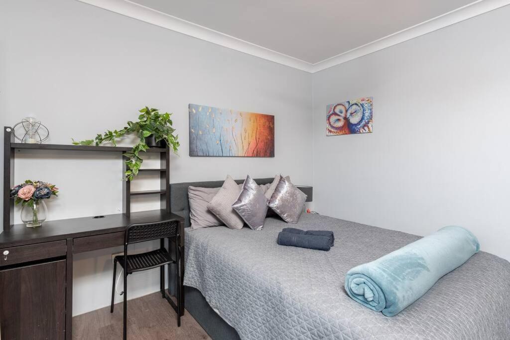 a bedroom with a desk and a bed with a blue pillow at 1 Private Double Room in Berala near Station close to Olympic Park in Regents Park