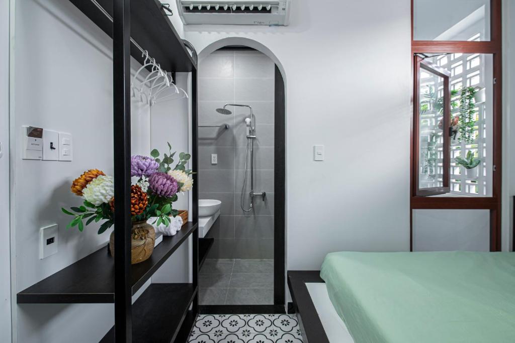 a bedroom with a bathroom with a shower and a bed at Nhà Bà Tư Boutique Homestay in Vung Tau