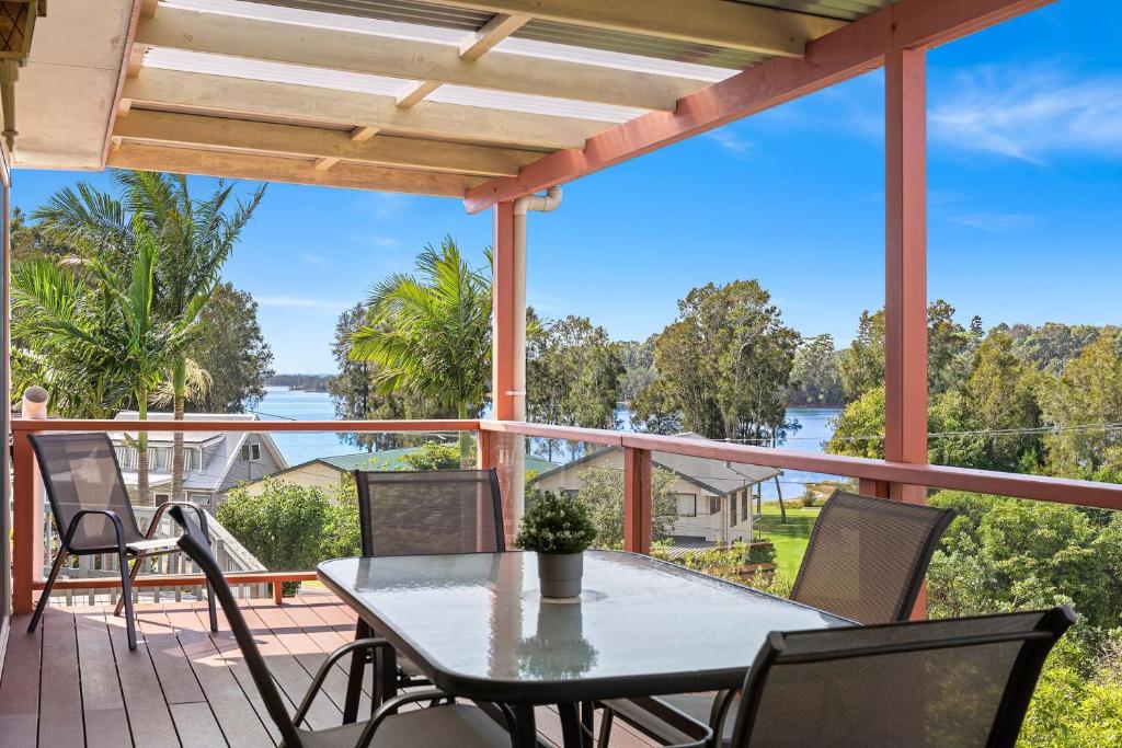 a patio with a table and chairs and a view of the water at 28 Nioka Street in Dalmeny