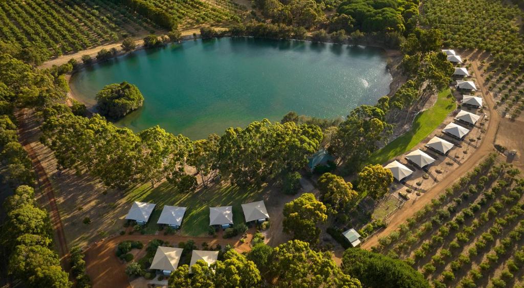 an aerial view of a lake with tents and trees at Olio Bello Lakeside Glamping in Cowaramup