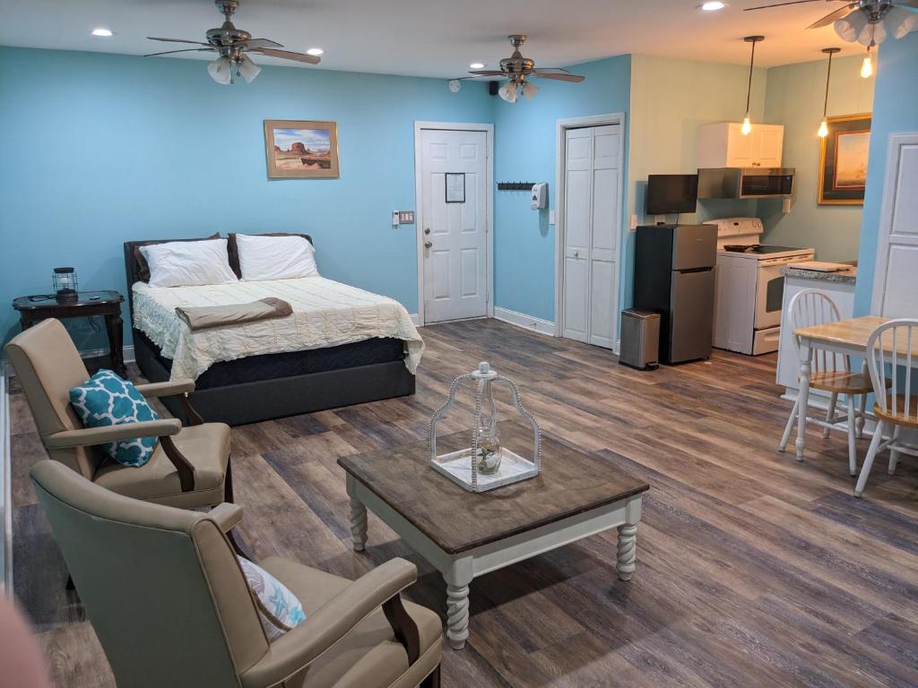 a living room with a bed and a table and chairs at Cozy studio with movie theater, beach 5 min away in Morehead City