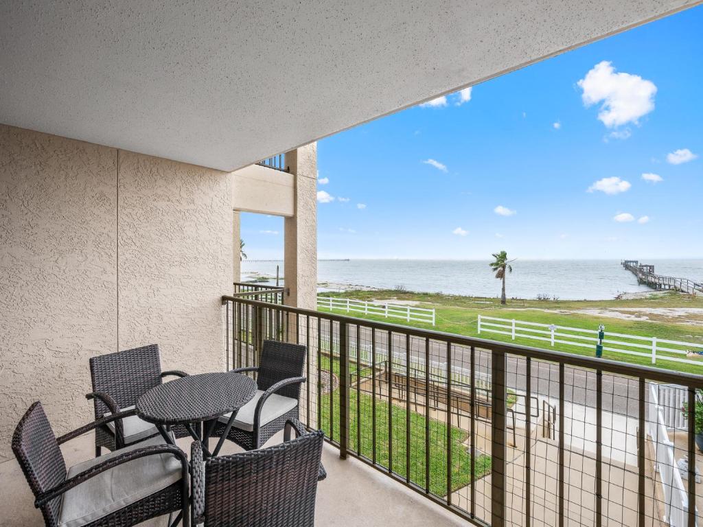 a balcony with a table and chairs and the ocean at LR 205 - La Las in Rockport